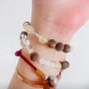 Collection of crystal bracelets with natural gemstone beads displayed on wooden surface for beginner guide