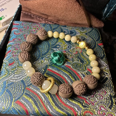Crystal bracelet for meditation with natural gemstone beads placed on yoga mat with candle light