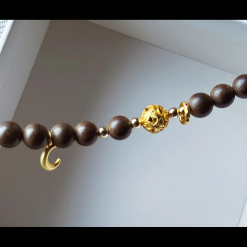 Close-up view of the Rose Serenity Handcrafted Bracelet showcasing wooden beads and golden accents.