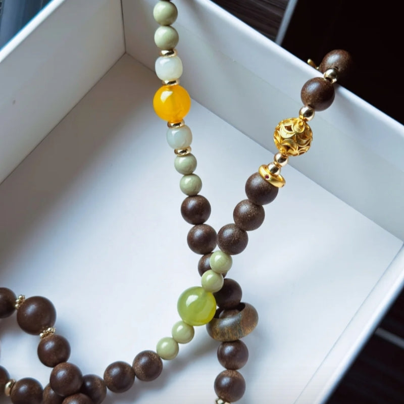 Mint & Perilla Serenity Bracelet by Laxne Moyu Fang displayed in a white box, showcasing handmade herbal beads.