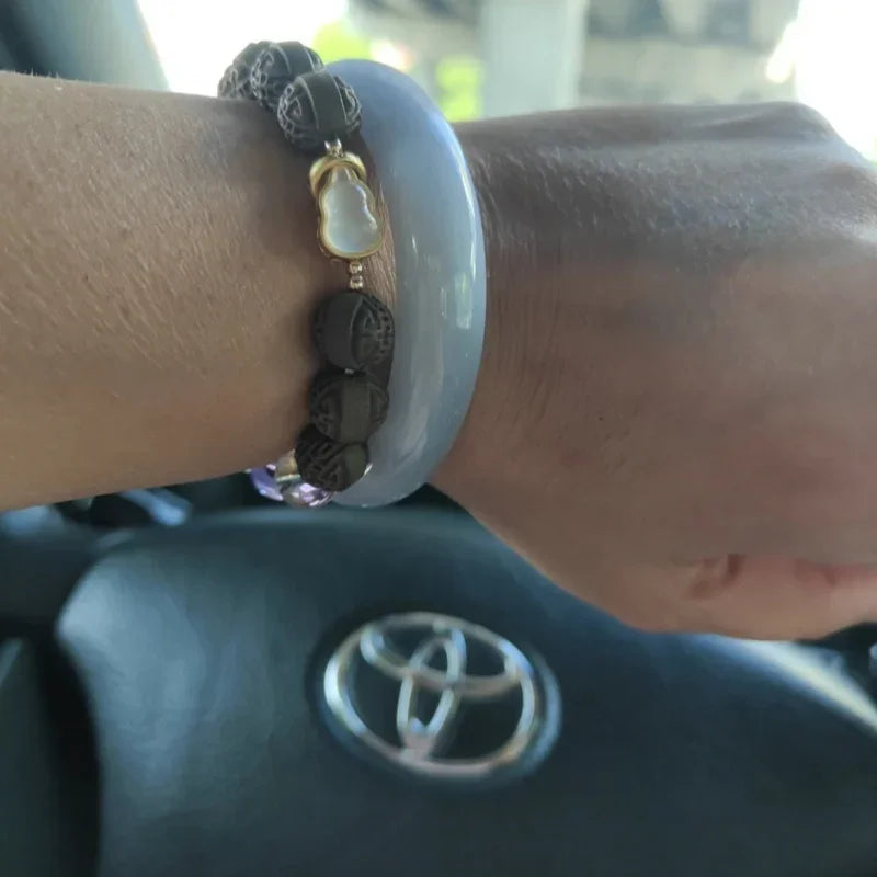 Close-up of handcrafted Xi herbal beads on crystal bracelet